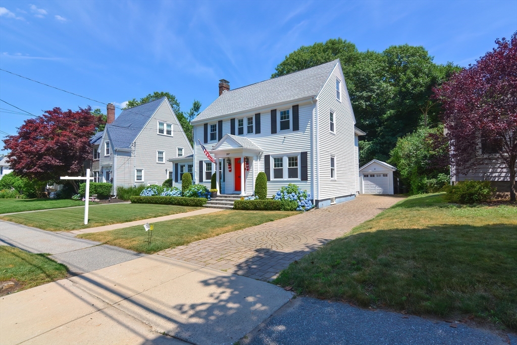 207 Lawrence Road Medford, MA 02155 - Photo 3 of 42 a view of a white house with a yard and table and chairs under an umbrella