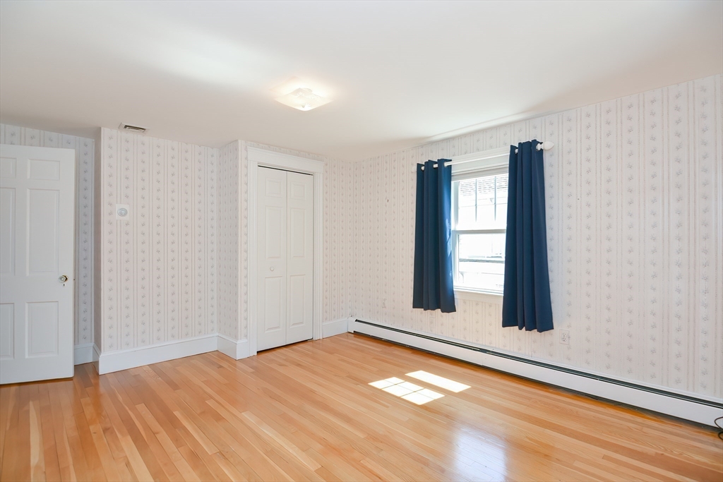 207 Lawrence Road Medford, MA 02155 - Photo 33 of 42 a view of an empty room with window and wooden floor