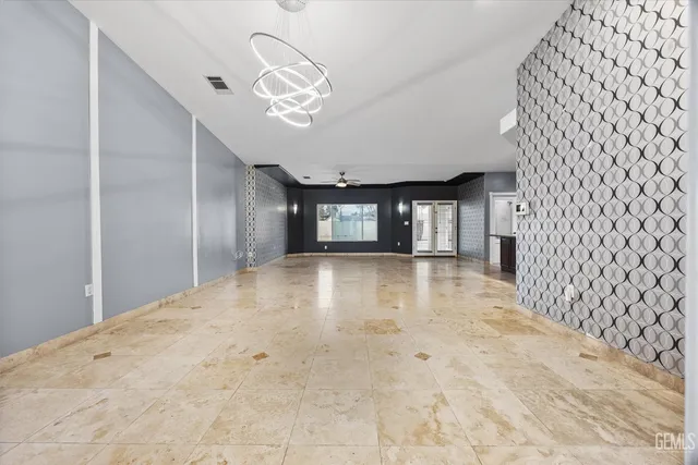 wooden floor in an empty room with a chandelier