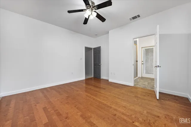 an empty room with closet and a ceiling fan