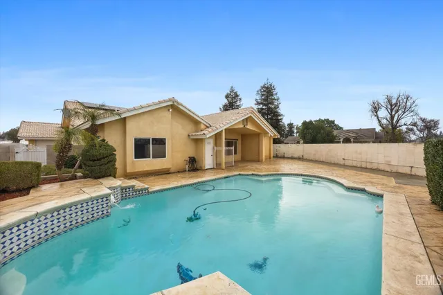 a view of a house with pool and yard