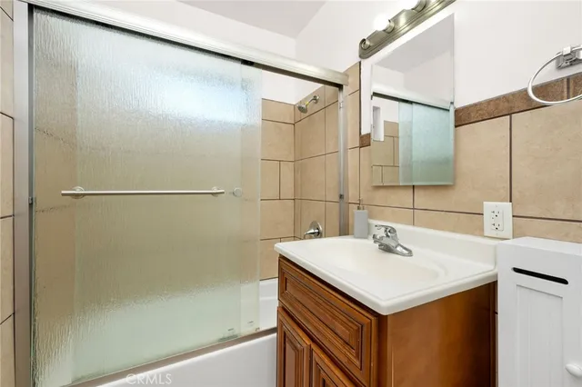 an empty room with wooden floor ceiling fan and window
