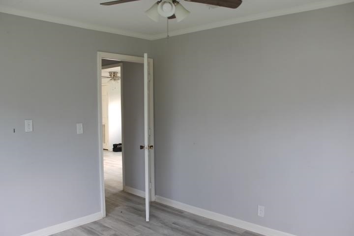 875 Woodrow Street Silsbee, TX 77656 - Photo 24 of 30 an empty room with wooden floor and a ceiling fan