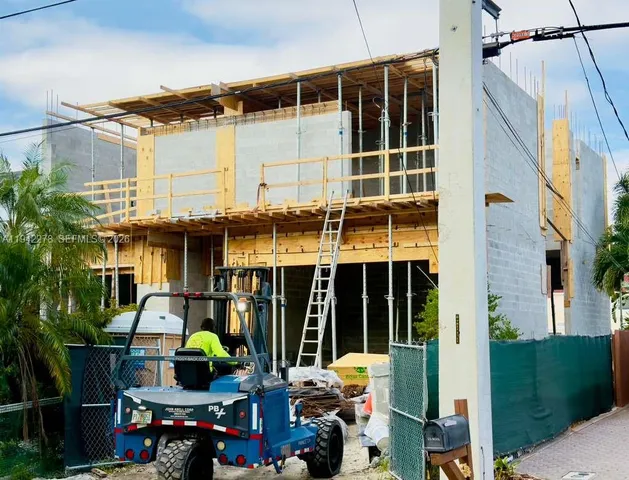 a front view of a house with balcony and trees