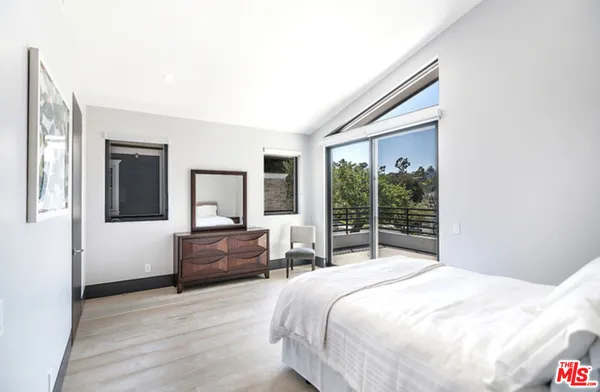 a bedroom with a bed and a large window