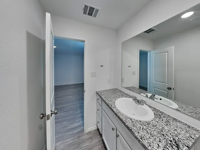 a bathroom with a granite countertop sink and a mirror