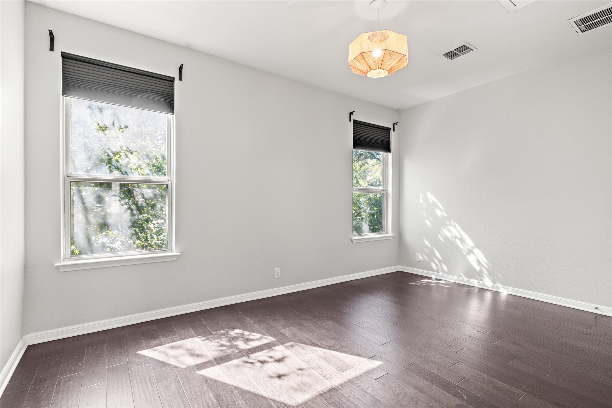 7337 Menchaca Road, Unit #22 Austin, TX 78745 - Photo 20 of 25 Spacious upstairs bedroom with wood floors and views of the back yard.