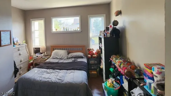 a bedroom with a bed a window and dresser