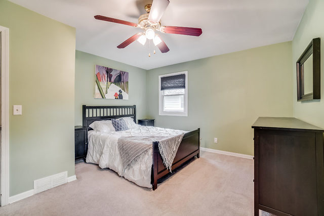 59 Neil Road Sugar Grove, IL 60554 - Photo 13 of 22 a bedroom with a bed and a chandelier