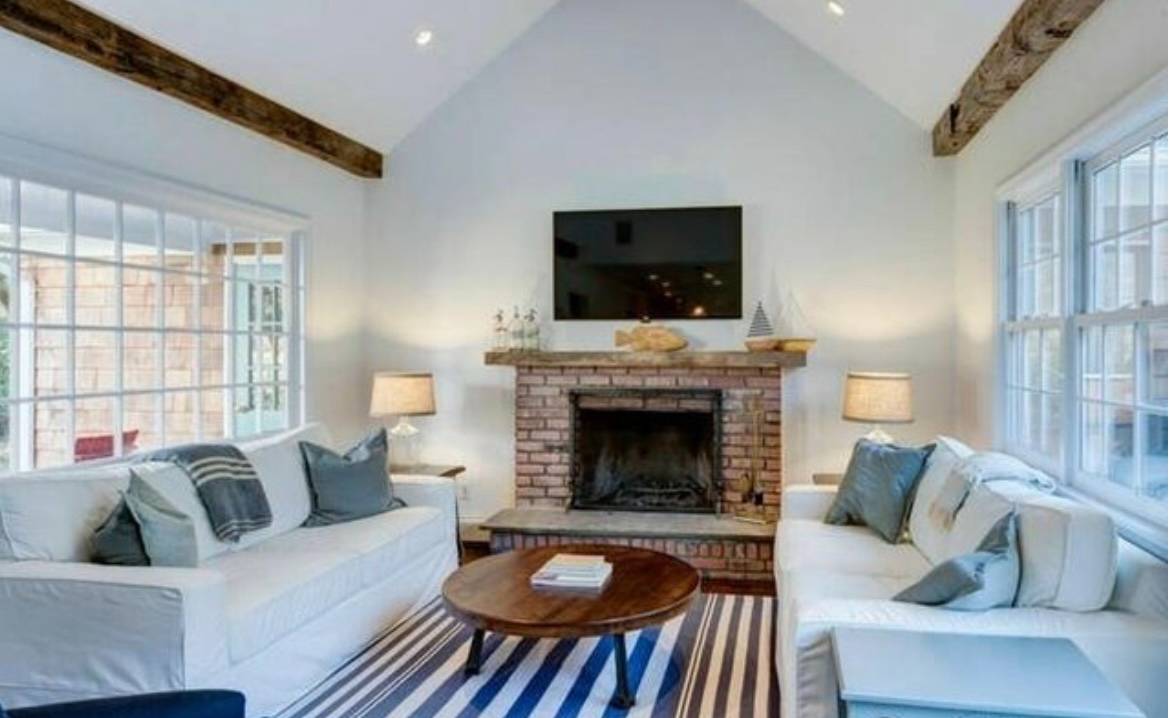 37 Foster Road Quogue, NY 11959 - Photo 3 of 11 a living room with furniture a flat screen tv and a fireplace