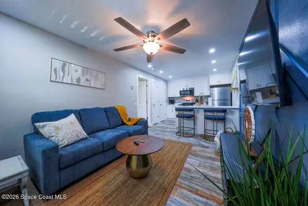 a living room with furniture and kitchen view