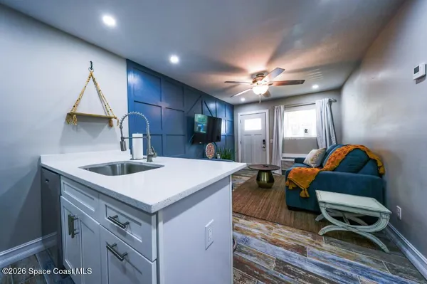 a view of kitchen island with sink appliances and cabinets