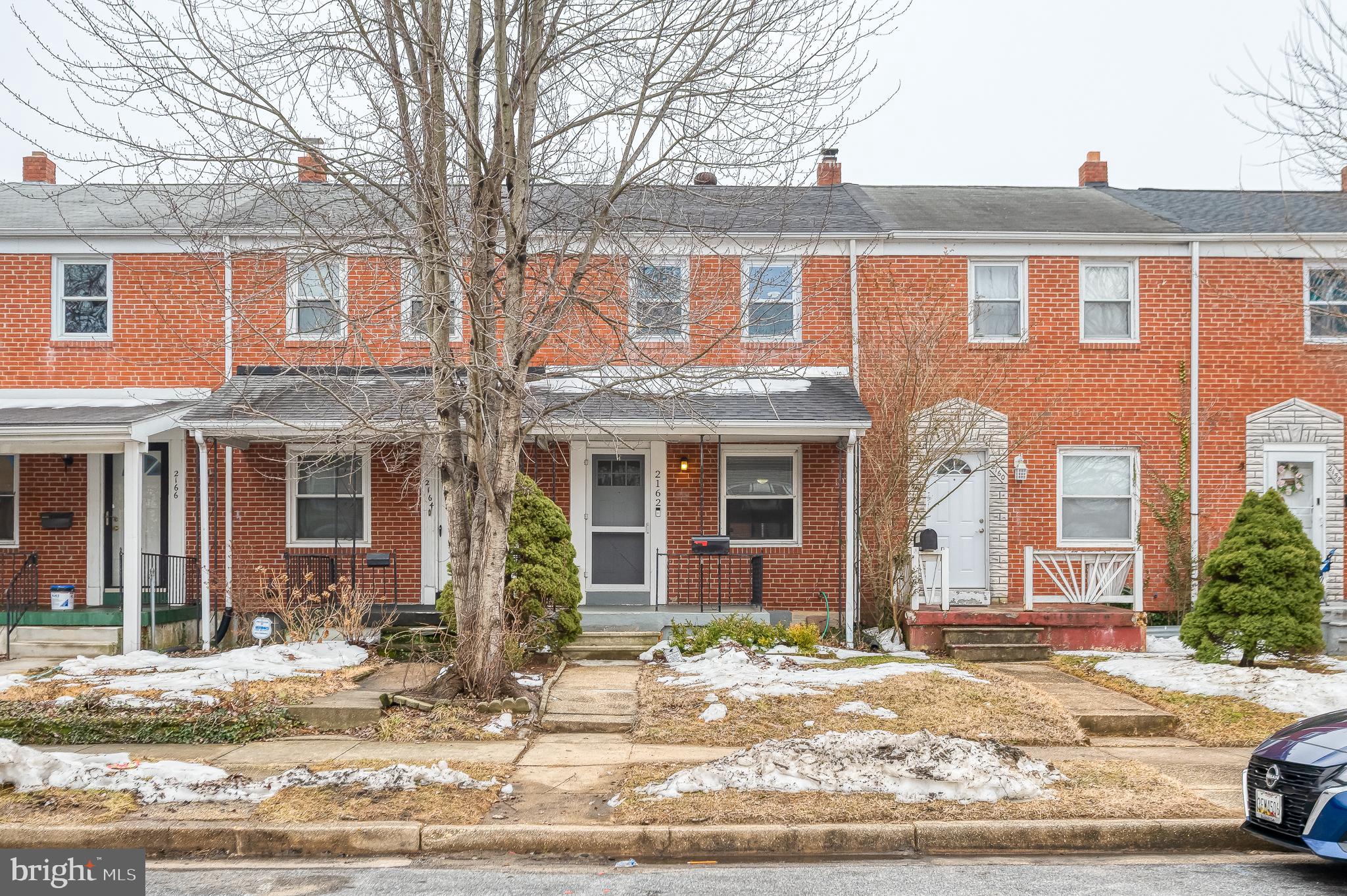 a view of a brick house with many windows and plants