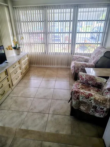 a living room with furniture and a floor to ceiling window