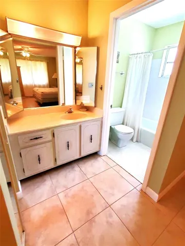 a bathroom with a sink a toilet a tub and shower