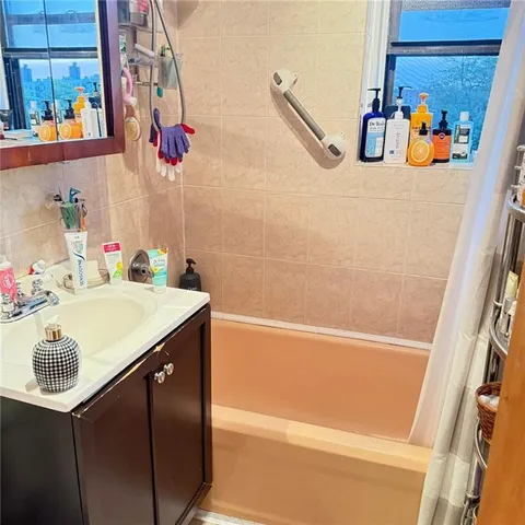 a bathroom with a sink vanity and a tub