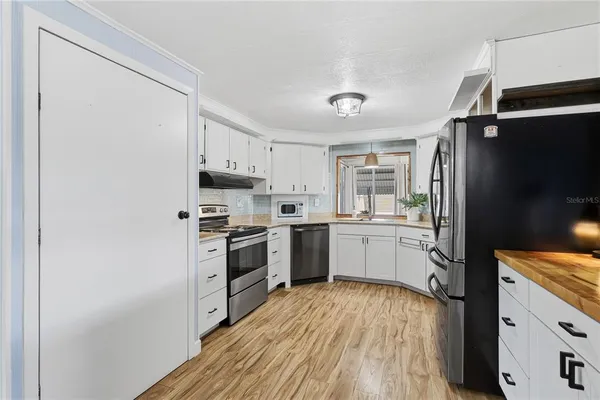 a kitchen with a refrigerator sink and stove top oven