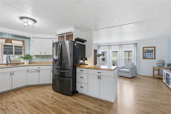 a kitchen with granite countertop a refrigerator stove top oven and sink