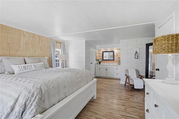 a spacious bedroom with a bed and a wooden floor