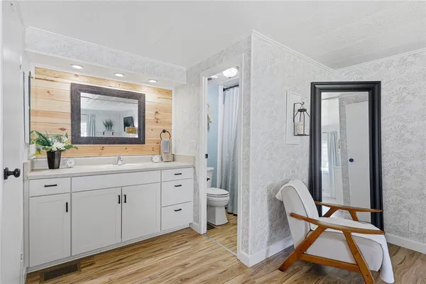 a spacious bathroom with a double vanity sink a mirror and a shower