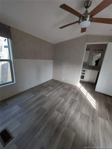 a gym room with wooden floor and windows