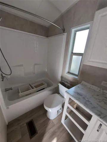 a bathroom with a granite countertop toilet sink and mirror