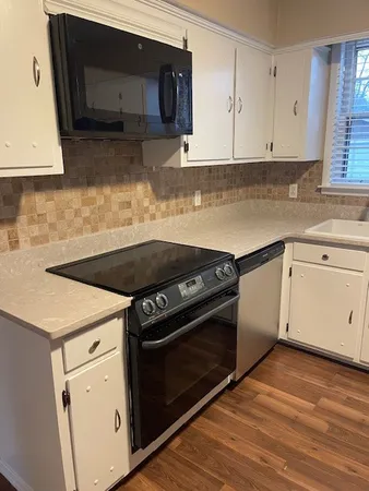 a kitchen with granite countertop white cabinets and white appliances