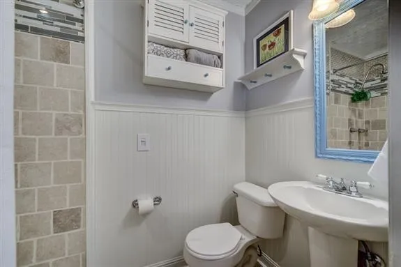 a bathroom with a toilet a sink and mirror