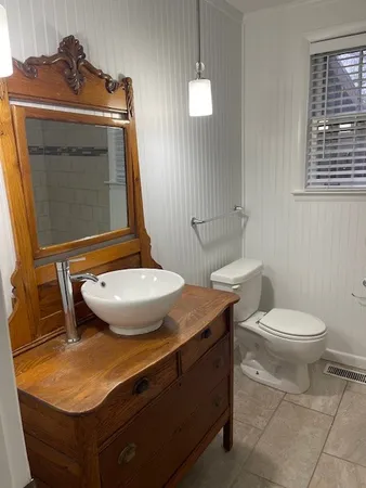 a bathroom with a granite countertop toilet and a sink
