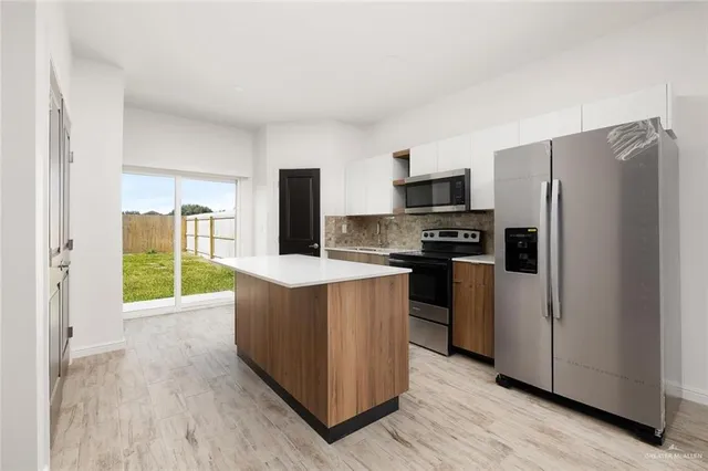 a kitchen with stainless steel appliances a refrigerator and a stove top oven