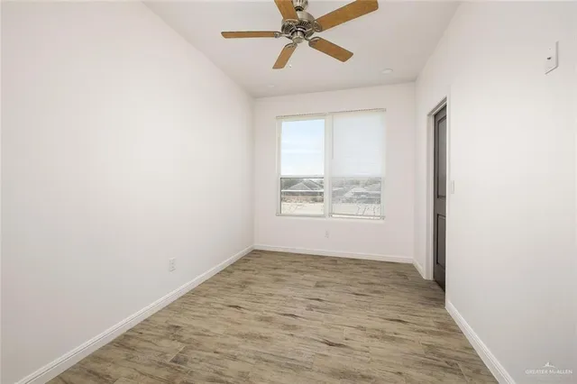 an empty room with windows and fan