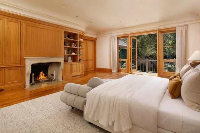 a bedroom with a bed and large windows