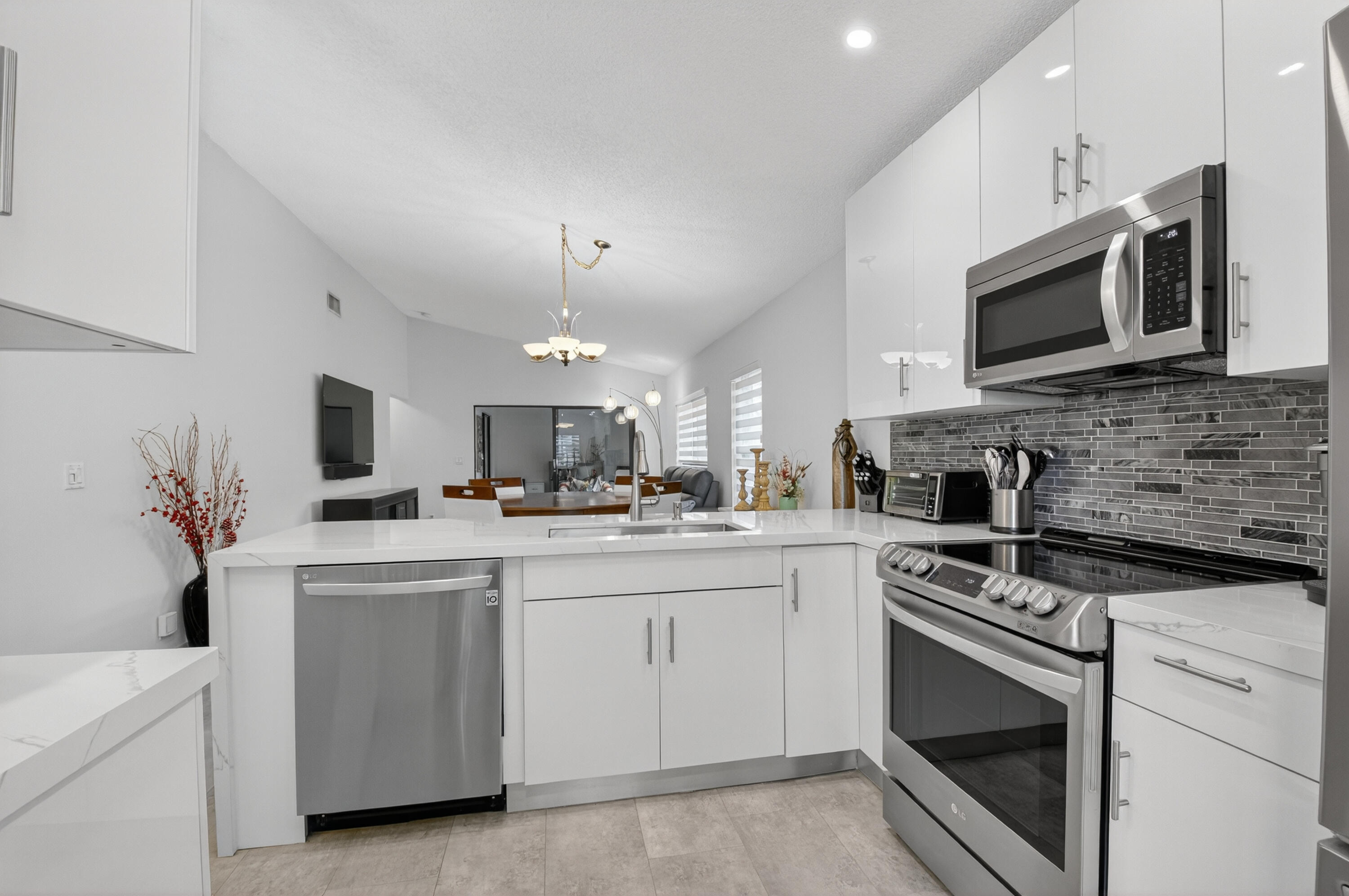 8136 Whispering Palm Drive, Unit B Boca Raton, FL 33496 - Photo 12 of 37 a kitchen with a sink stove and microwave