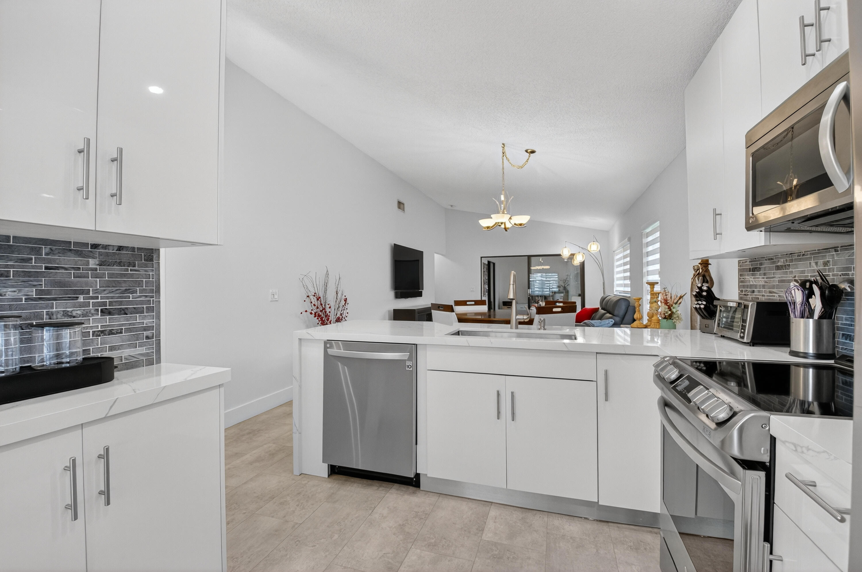 8136 Whispering Palm Drive, Unit B Boca Raton, FL 33496 - Photo 13 of 37 a kitchen with cabinets a sink and appliances
