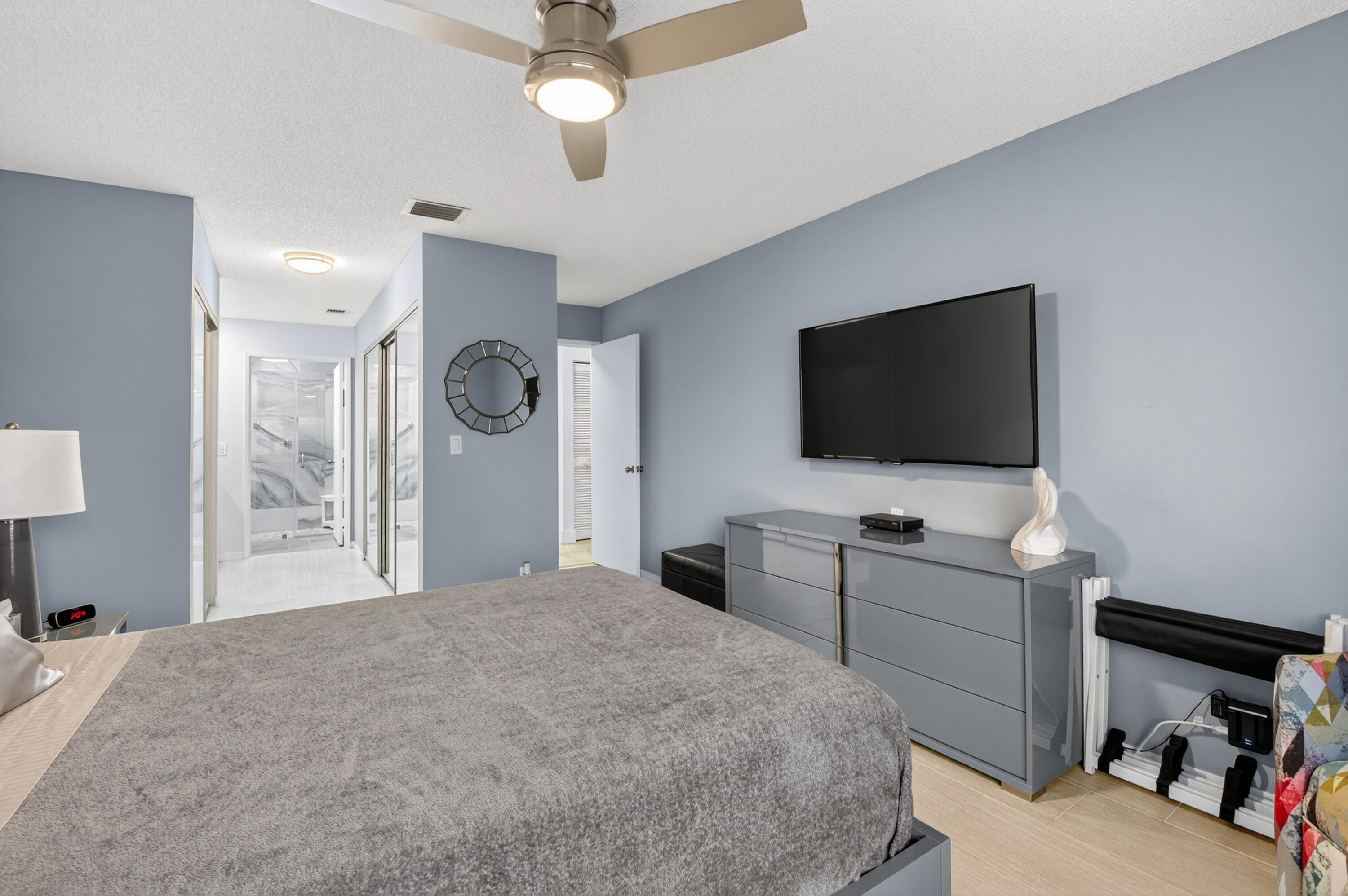 8136 Whispering Palm Drive, Unit B Boca Raton, FL 33496 - Photo 18 of 37 a bedroom with a bed and a flat tv screen on dresser