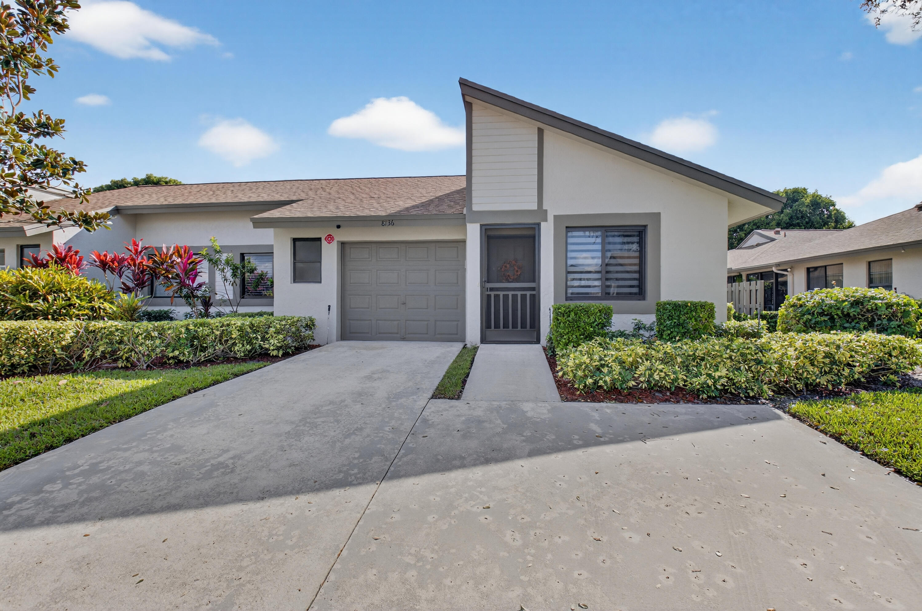 8136 Whispering Palm Drive, Unit B Boca Raton, FL 33496 - Photo 29 of 37 a front view of a house with a yard and garage