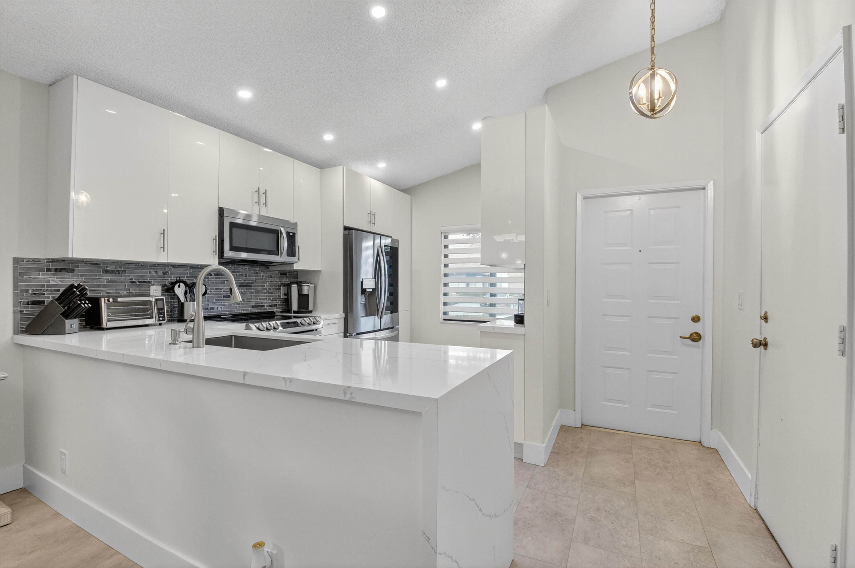 8136 Whispering Palm Drive, Unit B Boca Raton, FL 33496 - Photo 10 of 37 a kitchen with stainless steel appliances granite countertop a sink a stove and a refrigerator
