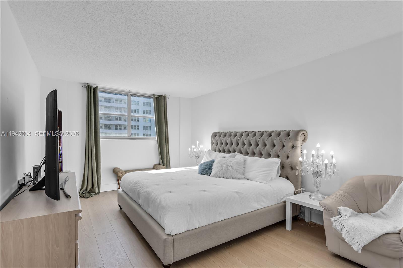 9273 Collins Avenue, Unit 503 Surfside, FL 33154 - Photo 19 of 48 a bedroom with a bed and a flat screen tv