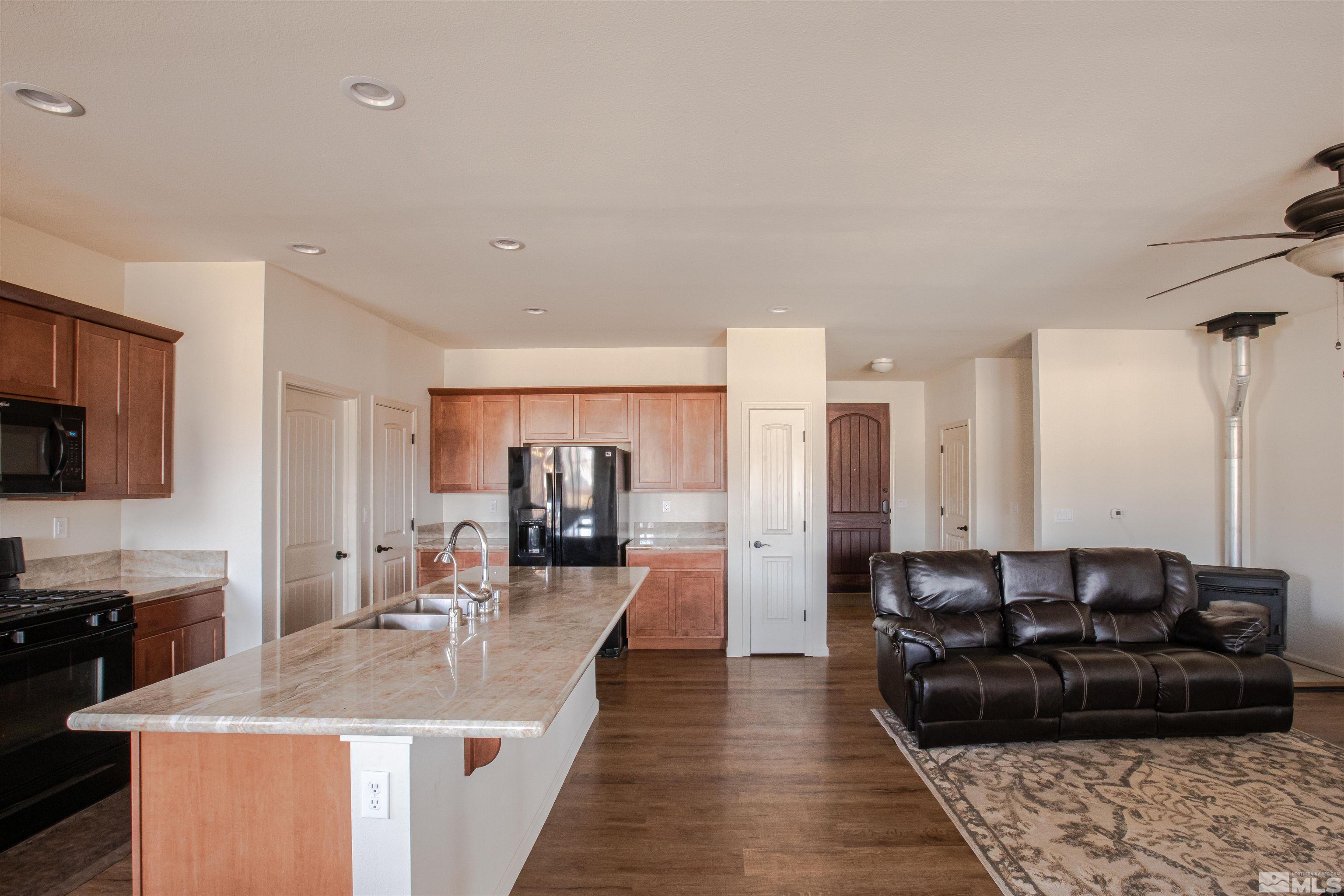 100 Wrangler Ranch Court Reno, NV 89510 - Photo 12 of 35 a living room with stainless steel appliances furniture a rug and a kitchen view