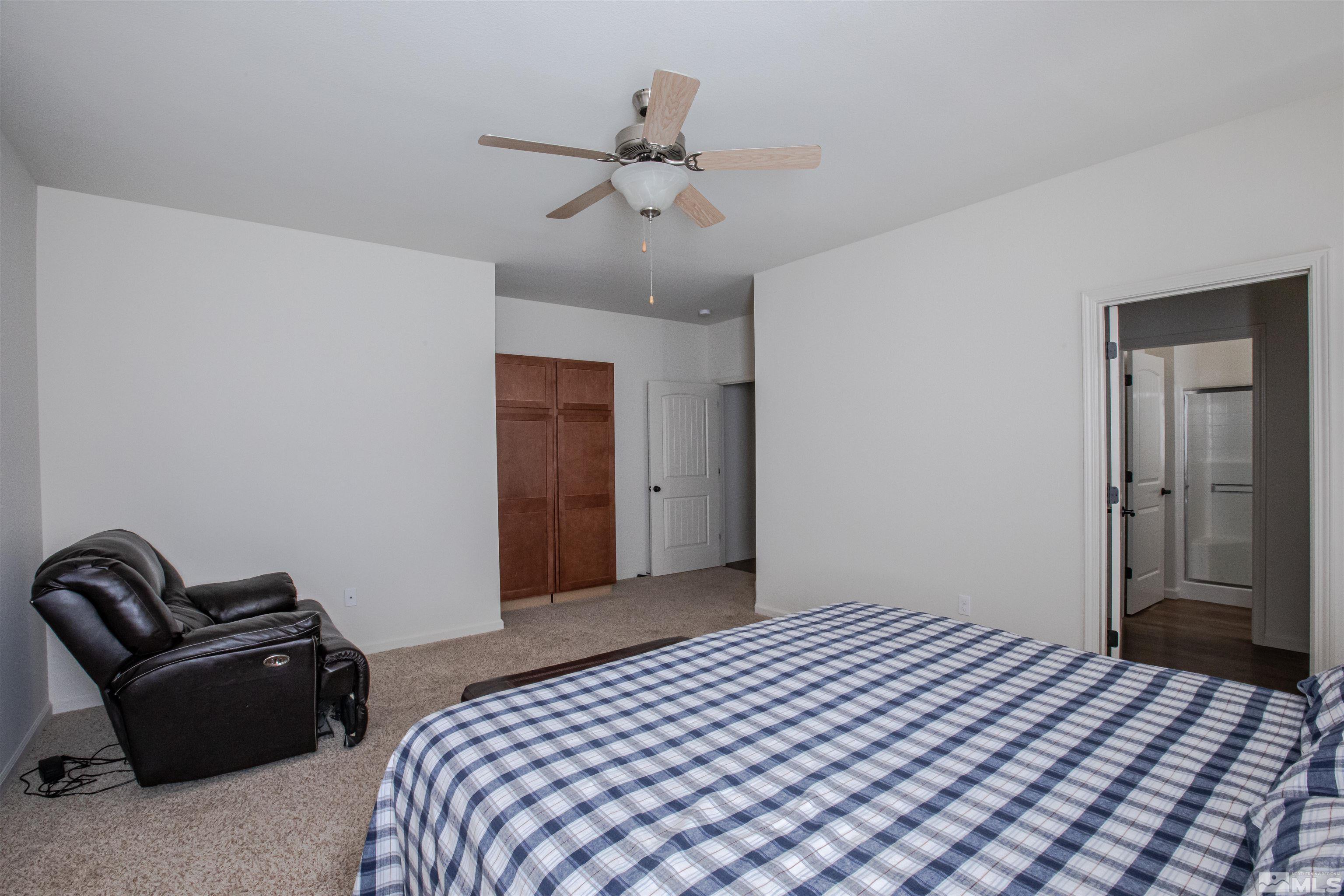 100 Wrangler Ranch Court Reno, NV 89510 - Photo 16 of 35 a bedroom with a bed and ceiling fan