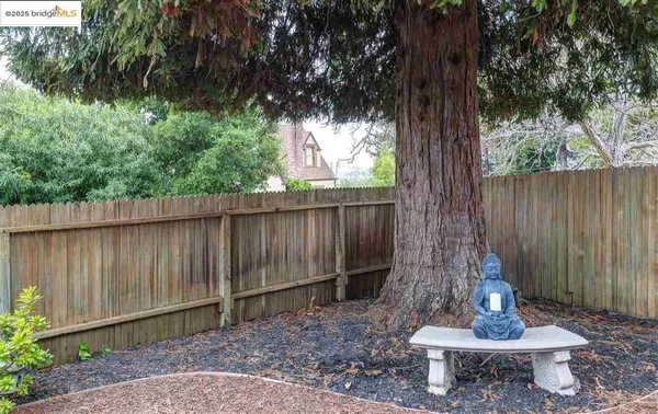 a fire pit in front of a yard with wooden fence