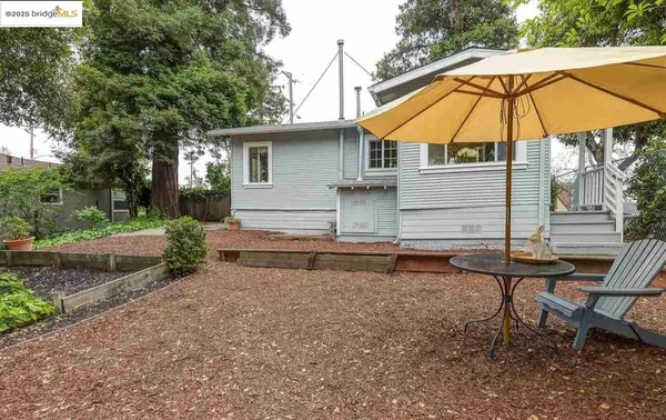 a view of a house with backyard and sitting area