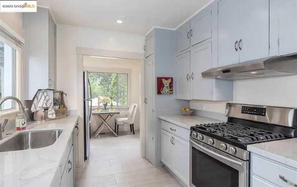 a kitchen with granite countertop a sink stove and cabinets