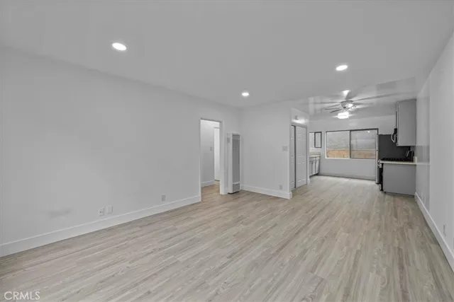 a view of a big room with wooden floor and windows