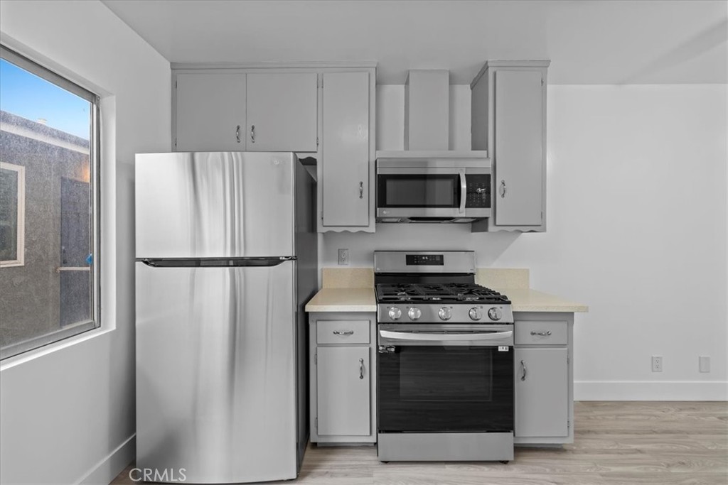 853 West 23rd Street, Unit 2 San Pedro, CA 90731 - Photo 11 of 19 a kitchen with cabinets stainless steel appliances and wooden floor