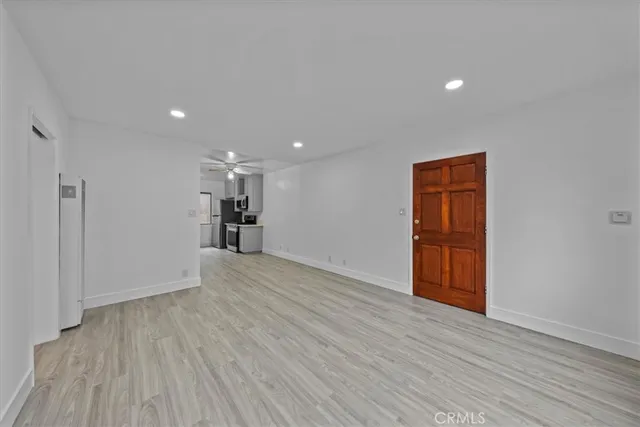 a view of empty room with wooden floor and window