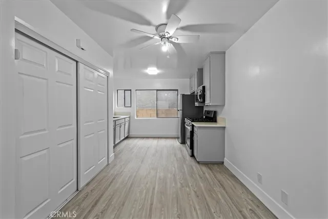 a view of a kitchen with a sink and dishwasher a refrigerator with wooden floor