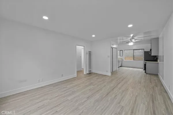 a view of a big room with wooden floor and windows