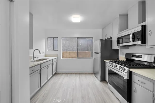 a kitchen with granite countertop a sink cabinets and stainless steel appliances