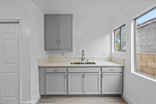 a kitchen with stainless steel appliances granite countertop a sink and cabinets with wooden floor